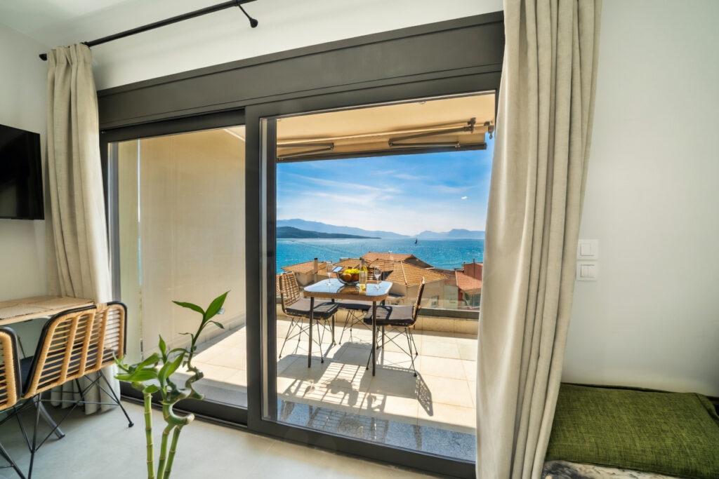 Poseidon Sea View Apartments in Nikiana, Lefkada with panoramic Ionian Sea view, modern interiors, and spacious balcony.