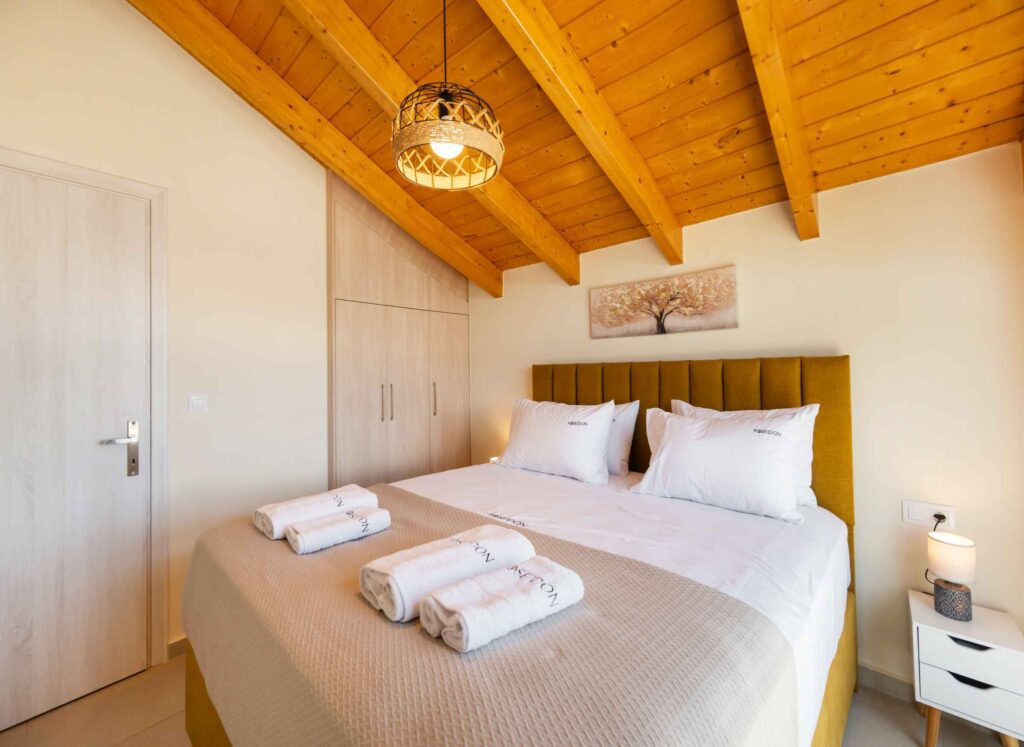 Bright master bedroom at Poseidon Maisonette in Nikiana, Lefkada, featuring a comfortable double bed, modern furnishings, and a relaxing atmosphere.