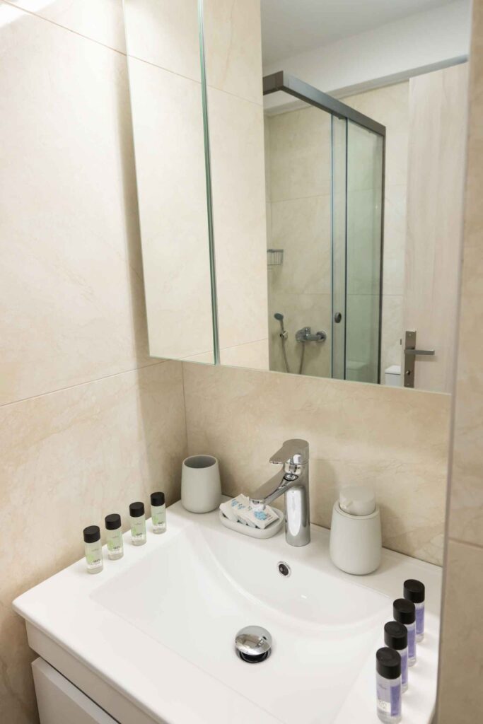Modern bathroom at Poseidon Maisonette in Nikiana, Lefkada, featuring a walk-in shower, contemporary design, and essential amenities.